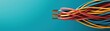 © Mnt - Colorful electrical wires on a vibrant turquoise background for modern tech visuals.
