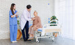 © Bangkok Click Studio - Asian senior woman sit on bed while consulting with doctor and caring nurse checking in hospital, Healthcare elderly patient and medical professional support muscle injury consultation wellness being.