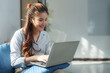 © crizzystudio - Happy businesswoman working remotely on a laptop, enjoying the comfort of her home office. Embracing flexibility and productivity while smiling in a relaxed atmosphere