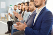 © Studio Romantic - Close up shot of a diverse business people applauding during an office event. The teamwork-driven meeting highlights company success and collaboration within the professional team.