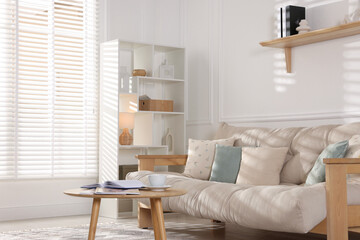 Poster - Beautiful sofa with cushions and coffee table in living room. Interior design