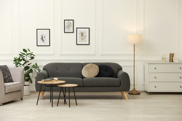 Poster - Stylish living room interior. Grey sofa, armchair and nesting tables indoors