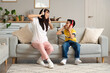© Pixel-Shot - Young mother and her little son in modern headphones listening to music at home