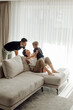 © andriyyavor - Happy family playing together on comfortable sofa in living room