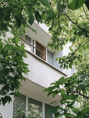 Aufkleber - Modern Urban Living Framed by Lush Green Leaves Featuring Apartment Windows : Generative AI
