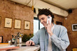 © Bliss - Charming young man enjoying a casual moment at the cafe while engaged in a phone conversation
