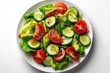 © Alive - Fresh green salad with tomatoes, cucumbers, and olive oil drizzled served on a white plate