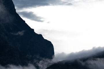 Wall Mural - dramatic mountain ridge above treed hills with mist and partially transparent sky
