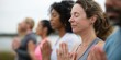 © gunzexx png and bg - Participants engage in a group meditation session by the serene waters of a lake, focusing on mindfulness, unity, and inner peace in a tranquil environment.
