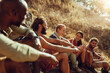 © Marko Geber - Group of friends resting and laughing during a sunny hiking adventure in the hills