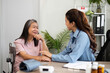 © wichayada - Emotional Support and Patient Interaction. A nurse comforts an elderly woman during a health consultation.