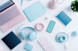 © Amal - Pastel-colored tech gadgets and accessories arranged on a white surface.