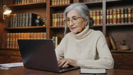 Poster - a woman sits in front of a laptop with a focused expression, highlighting her dedication to work.