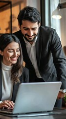 Poster - Two business colleagues, a man and a woman, collaborate over a laptop in a bright office space. They're focused on the screen, sharing a positive and productive working moment together.