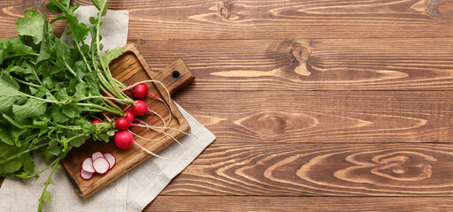 Wall Mural - Board with fresh radishes on wooden background