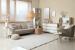 © Pixel-Shot - Interior of living room with sofa, armchair, shelving units and blooming branches in vases on tables