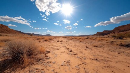 Poster - Vast desert landscape under bright sunlight and a clear blue sky with scattered clouds and rock formations extending towards the horizon