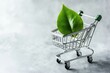 © Agri - Miniature shopping cart with a vibrant leaf, symbolizing sustainable shopping.
