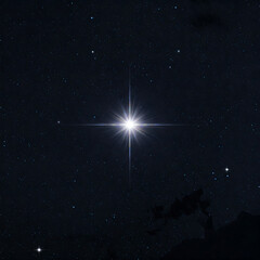 bright star shines intensely against a dark expanse of the night sky filled with distant stars