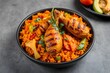 © prarthana - A bowl of spicy saffron basmati biriyani with fried chicken legs.