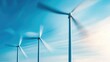 © Lilly - Dynamic image of offshore wind farm with turbines spinning rapidly, motion blur of blades against blue sky