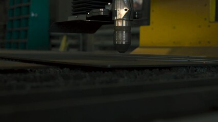 Fototapete - Witness the intricate process of metal part fabrication as a laser cutting machine expertly shapes sheets of metal. This advanced technology showcases precision and efficiency in manufacturing.