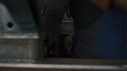 Fototapete - A skilled worker is focused on cutting and grinding a metal piece with a pneumatic metal cutting machine in an industrial workshop. The atmosphere is filled with focus and craftsmanship.