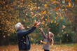 © Татьяна Евдокимова - Grandfather and granddaughter throwing colorful autumn leaves in a park, enjoying a beautiful fall day together