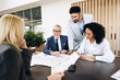 © Maria Vitkovska - Business team analyzing blueprint and financial reports in modern office