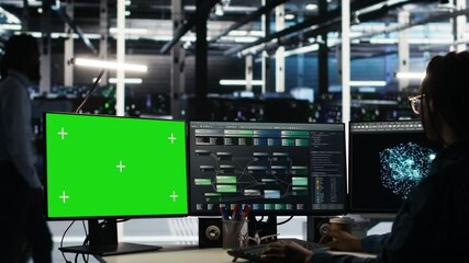 Data center technician using node tree software on green screen PC to analyze datasets. Server room worker using visual programming tools on chroma key computer to improve gear performance, camera B