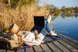 © encierro - Woman freelancer reclining by the lake with laptop enjoying nature while remote working