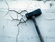 © Nakula - Close-up of a hammer striking a cracked wall, highlighting damage and repair efforts