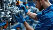 © Mrammon - A man in a blue shirt is working on a machine