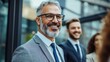 © Oleksandr - Confident Mature Businessman Smiling with Colleagues Outdoors Near Modern Office Building