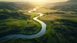 © cllareta - Aerial view of a meandering river flowing through a lush green valley at sunset.