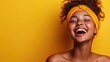 © Freshpixel - The image showcases a joyful woman laughing heartily, framed by a vibrant yellow background that enhances her radiant smile and carefree spirit, embodying happiness and warmth.