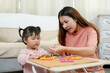 © Ekkasit A Siam - Young Asian single mother teaching little daughter creative art activity with colorful clay on table while spending learning time together at home promoting development in early childhood education