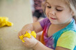 © Austockphoto - Little girl squishing playdough in her fingers