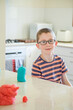 © Austockphoto - Eight year old boy making play dough creations inside