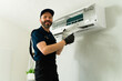 © AntonioDiaz - Hvac technician cleaning air conditioner filter during maintenance service