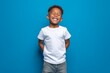 © Khawla - Happy smilling boy wearing bella canvas white shirt mockup, at blue background. Design tshirt template, print presentation mock-up