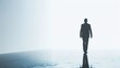 © PegawaiNegriStock - Silhouette of a businessman walking towards a bright horizon on a reflective surface, symbolizing ambition