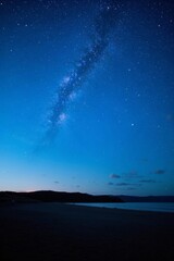 Wall Mural - starry sky over a beach with a bench and a body of water