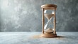 © Maryna - Wooden hourglass concept time management. Sand flowing inside glass timer passage time. Time running out concept. Background concrete surface. Time, business, productivity, planning concept.
