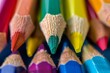 © Iftikhar alam - A close-up view of colorful pencils, with a focus on the green one in the center, Use color and form to symbolize the transformative power of education