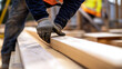© bussi - Construction Worker Handling Wooden Beams