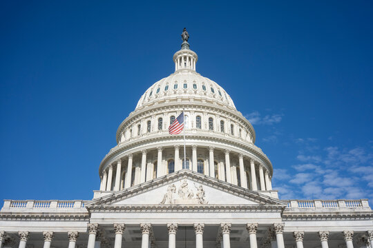 The United States Capitol dome against a clearing blue sky viewed from the east front of the U.S. Capitol building in Washington, DC.