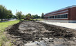 © one - Excavation work in progress beside a commercial building, showcasing heavy machinery and a clear sky
