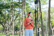 © Thitisak - Asian woman walks and listens to music in a public park.