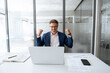 © Stock 4 You - Happy excited senior man sitting at desk in office working on laptop makes yes win gesture. Emotional mature businessman celebrate good business news, career growth, achievement, victory. Copy space